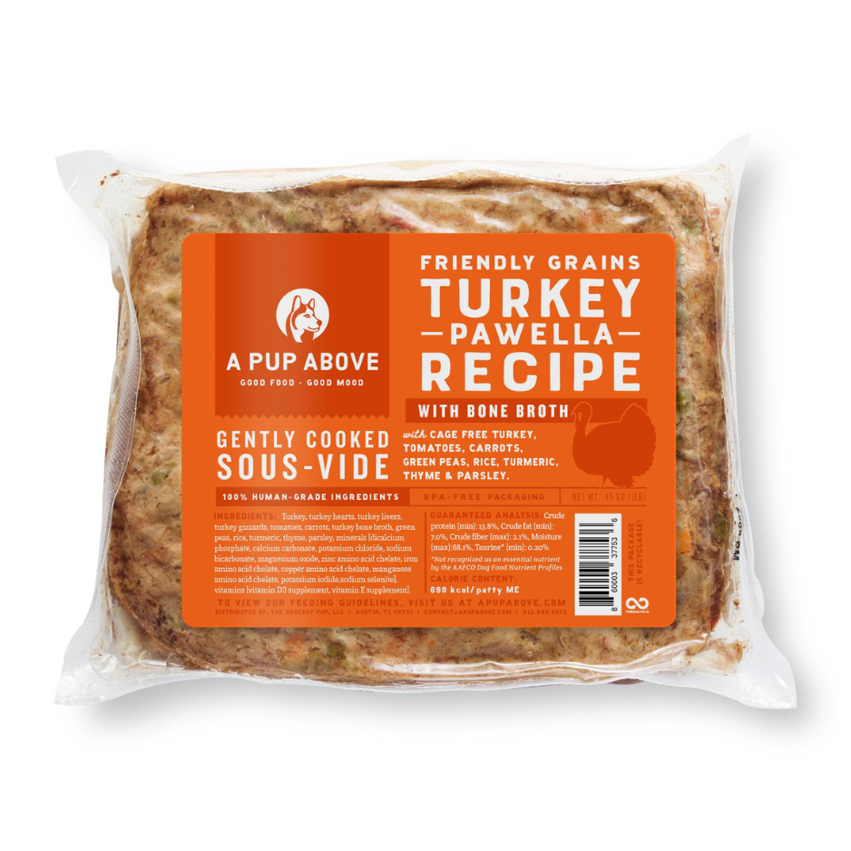 Vacuum-sealed package of A Pup Above Turkey Pawella Recipe dog food, featuring an orange label stating it is a friendly grains, gently cooked sous-vide recipe with cage-free turkey, bone broth, vegetables, rice, and herbs.