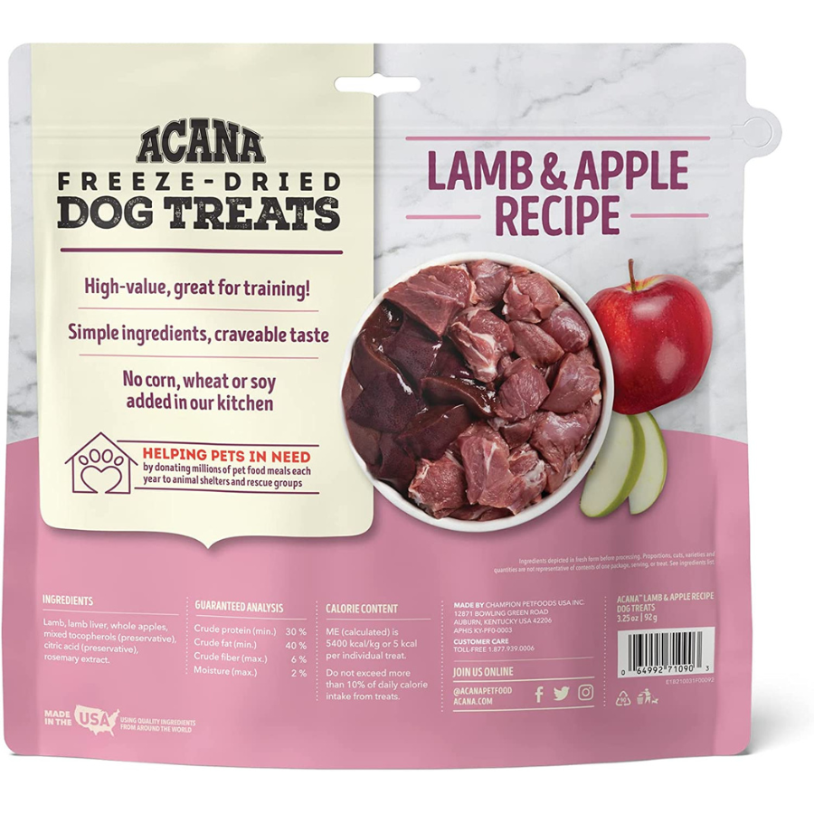 The full back view of the packaging. It highlights the treats as "High-value, great for training!" and specifies "No corn, wheat or soy added in our kitchen." The center features the image of raw lamb and apples. A section at the bottom left mentions "HELPING PETS IN NEED" by donating meals to animal shelters. The bottom right includes the barcode and manufacturer contact information.