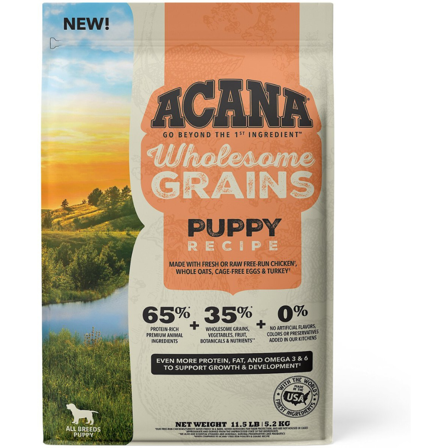 Front of ACANA Wholesome Grains Puppy Recipe dry dog food bag labeled “New,” highlighting 65% protein-rich animal ingredients, 35% wholesome grains and botanicals, 0% artificial additives, and support for puppy growth and development.