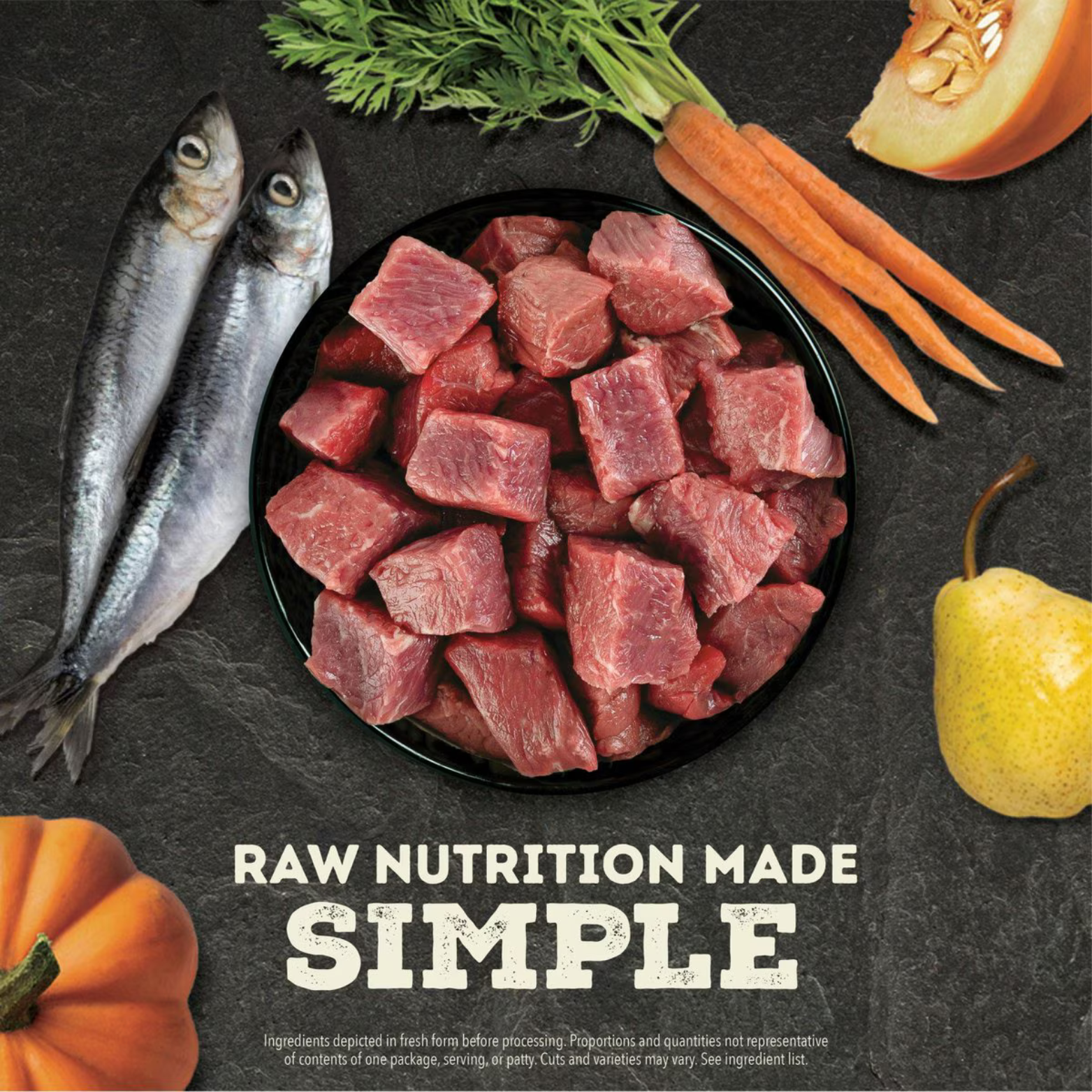 Bowl of raw beef cubes surrounded by whole fish, pumpkin, carrots, and a pear on a dark background, with the text ‘Raw Nutrition Made Simple.’