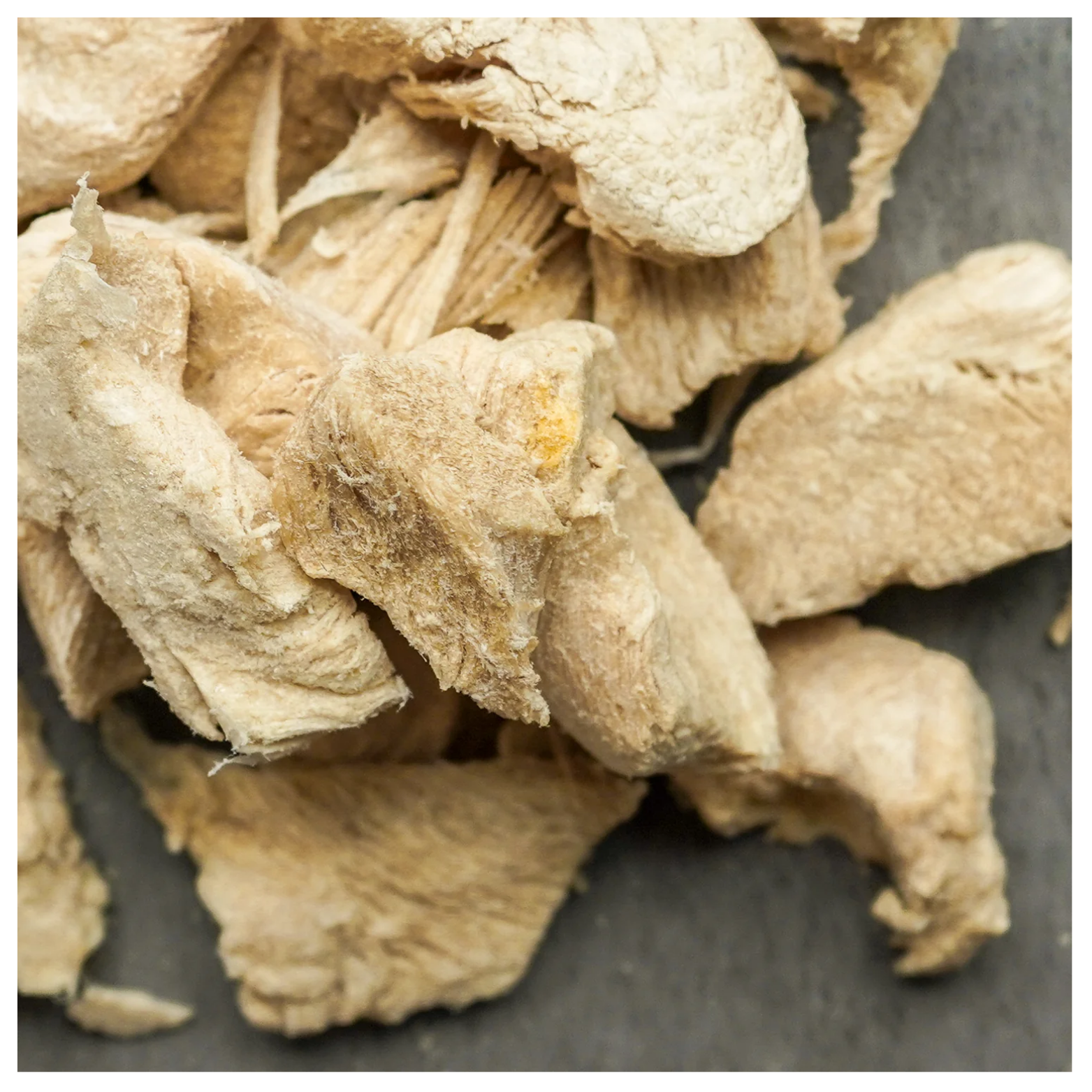 Extreme close-up of freeze-dried turkey pieces highlighting porous texture and layered fibers.
