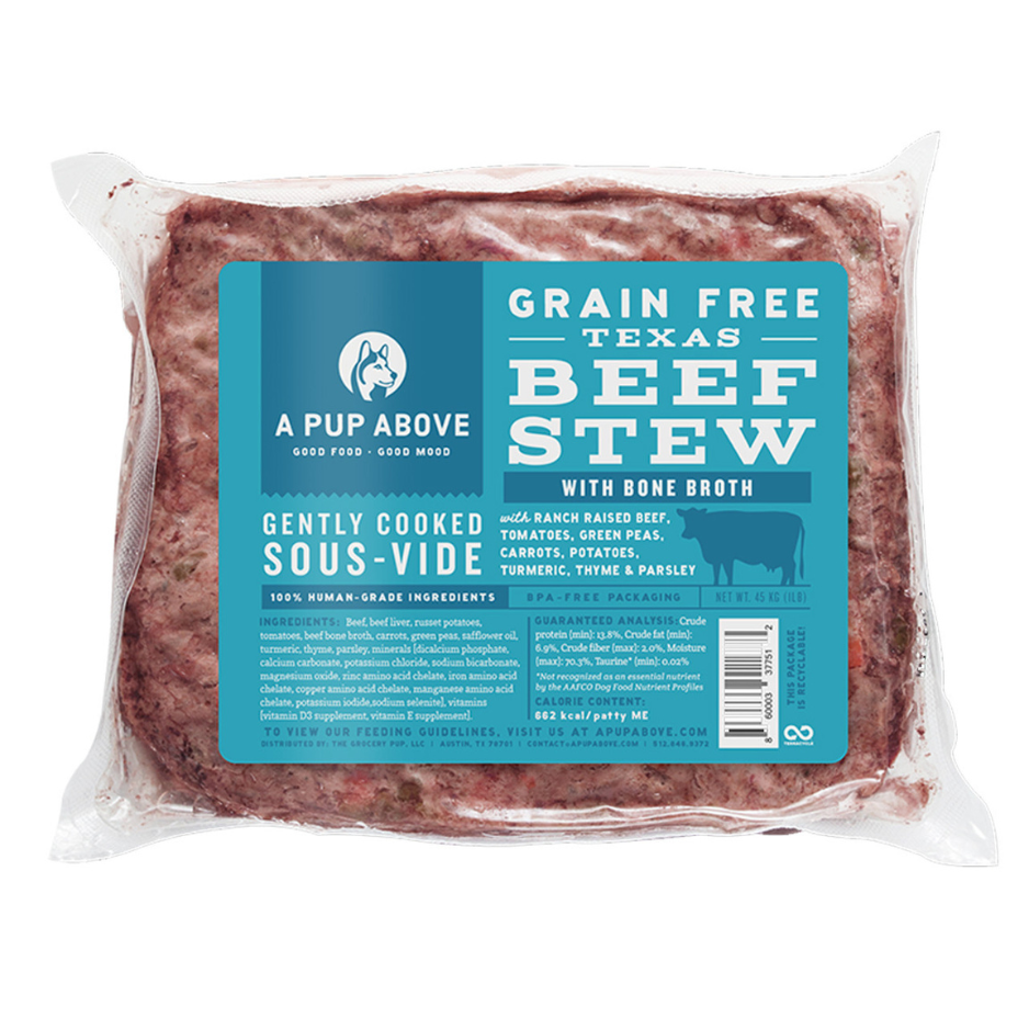 Vacuum-sealed package of A Pup Above Texas Beef Stew dog food, featuring a blue label stating it is a grain-free, gently cooked sous-vide recipe made with ranch-raised beef, bone broth, tomatoes, peas, carrots, potatoes, turmeric, thyme, and parsley.