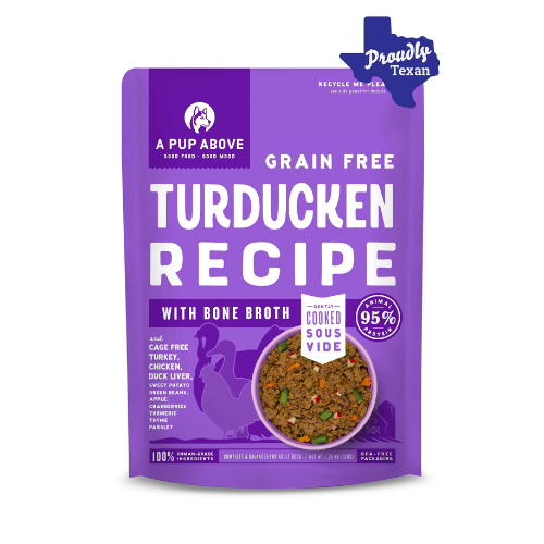 Purple bag of A Pup Above Grain Free Turducken Recipe dog food with bone broth, featuring an image of the cooked food, the claim ‘95% animal protein,’ and a ‘Proudly Texan’ label in the top right corner.