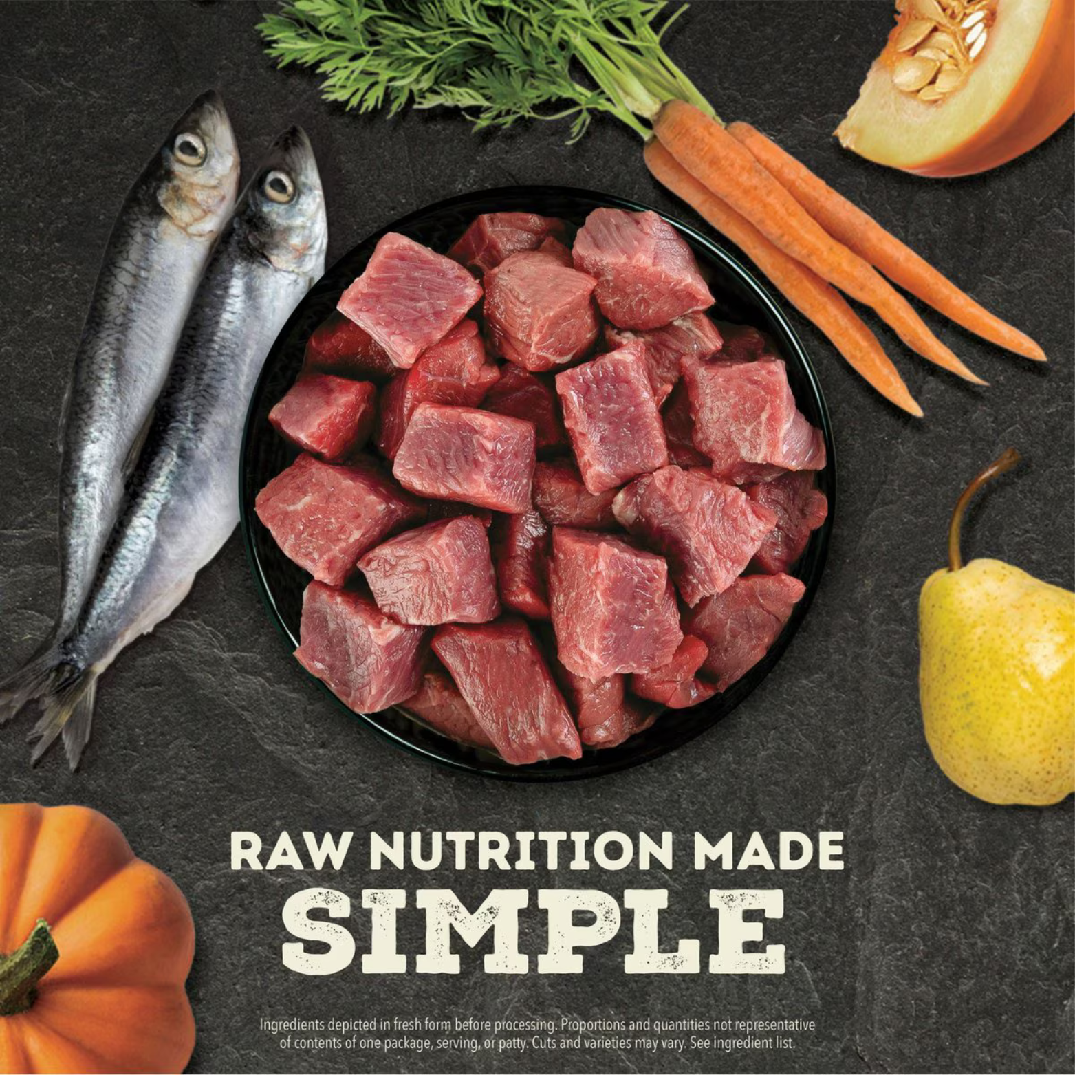 Bowl of raw beef chunks surrounded by whole herring, carrots with greens, pumpkin, and a pear, with the text “Raw Nutrition Made Simple.”