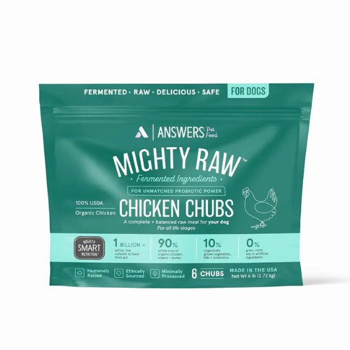 Front view of a green package of Answers Pet Food “Mighty Raw” fermented raw chicken chubs for dogs. The packaging highlights fermented ingredients, probiotic power, organic chicken, minimal processing, and U.S. production. The bag contains six raw chicken chubs with a net weight of six pounds and includes icons indicating smart nutrition, ethical sourcing, and suitability for all life stages.