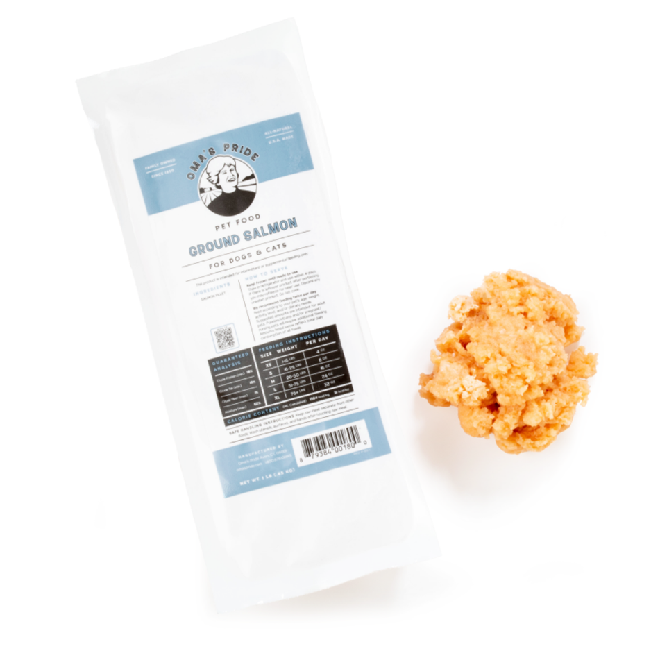 Vacuum-sealed package labeled “Oma’s Pride Pet Food Ground Salmon for Dogs & Cats” next to a mound of finely ground orange salmon on a white background.