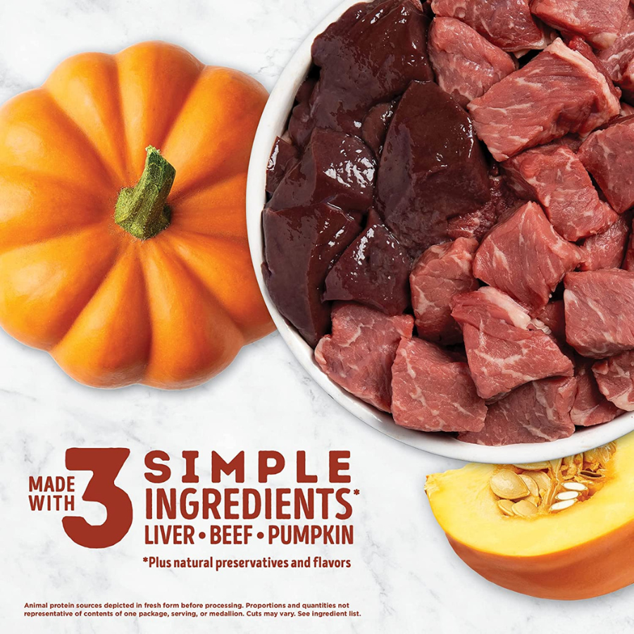 A close-up graphic emphasizing the product's ingredients. It shows a white bowl filled with fresh beef liver and beef cubes alongside a whole orange pumpkin and a sliced pumpkin piece. Large text reads "Made with 3 simple ingredients: Liver • Beef • Pumpkin," with a small footnote stating "plus natural preservatives and flavors."